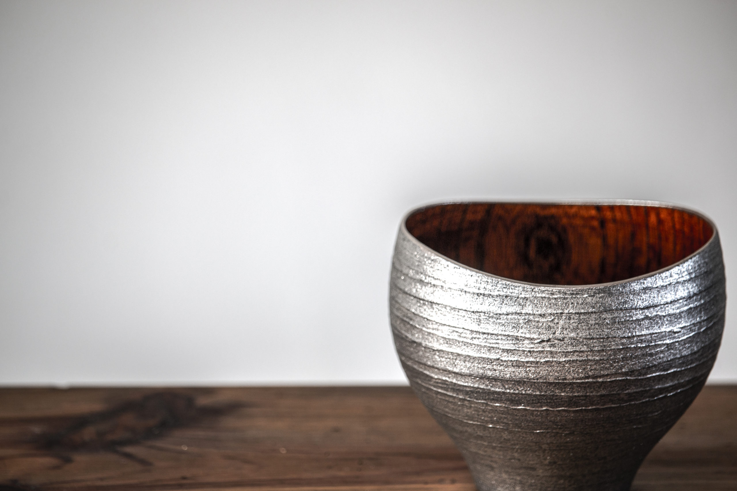 Cup with a silver-colored exterior and a wood-grain interior